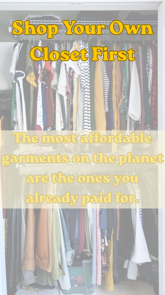 Women's fashion Pinterest pin from the file "Shop Your Own Closet First The most affordable garments on the planet are the ones you already paid for..webp". The image shows a full closet packed with a variety of colorful clothes hanging on upper and lower racks. Text overlay in bold yellow font reads "Shop Your Own Closet First" at the top and "The most affordable garments on the planet are the ones you already paid for" across the middle, sharing tips on building a budget-friendly Capsule Wardrobe.